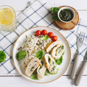 Куриное филе с рисом, шпинатом и овощами | Chicken fillet roll with spinach. Garnished with long-grain wild rice. Cherry tomatoes, pesto sauce, a glass of water and a slice