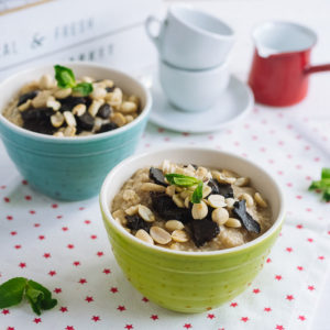 Овсяная каша с черносливом | Colored tall bowls with oatmeal with peanuts, prunes, mint leaves.