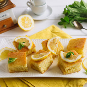 лимонный бисквит с меренгой | Square slices of lemon pie with slices of fresh lemon and mint leaves.