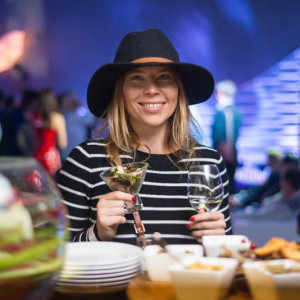 Девушка на вечеринке в шляпе и с бокалом белого вина
